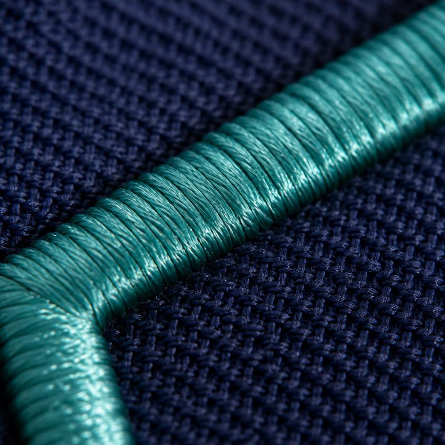 Close-up of dense embroidery stitching on a navy corporate polo placket